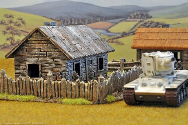 The KV-2 rumbles past the Area 9 long Farm House with Wooden Roof